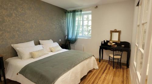 a bedroom with a bed and a table and a mirror at Château Puybarban in Puybarban