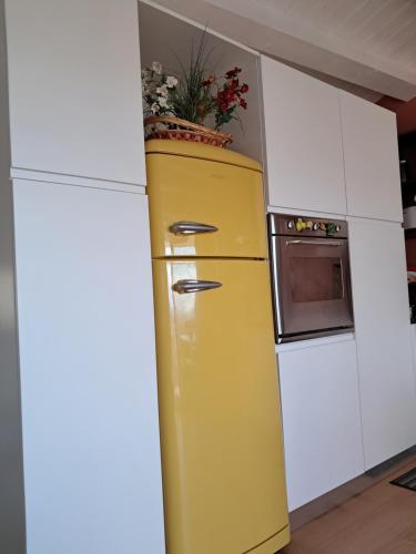 LeonforteにあるA casa do Caliaruの電子レンジのあるキッチンにある古い黄色い冷蔵庫