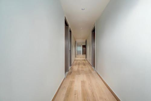 a long hallway with white walls and wood floors at Townhouse DSIDC Bawana Formerly Kanhaiya Residency in Bawāna