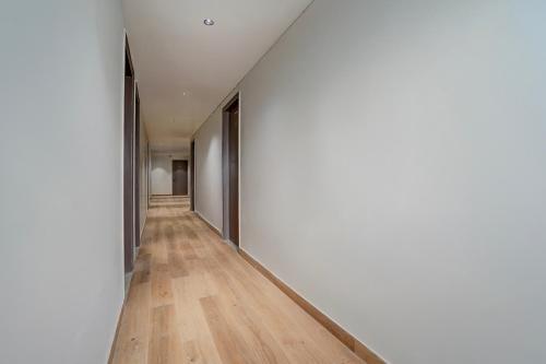 an empty hallway with white walls and wood floors at Townhouse DSIDC Bawana Formerly Kanhaiya Residency in Bawāna