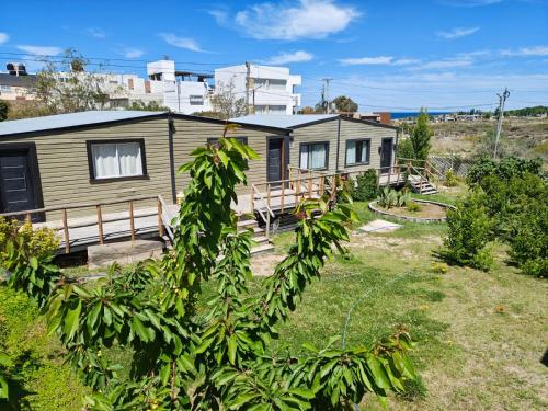 a home with a yard with a house at Las Cabañas in Las Grutas