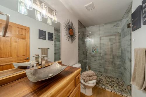 a bathroom with a sink and a glass shower at Cozy Cabin in Bison Ranch in Overgaard