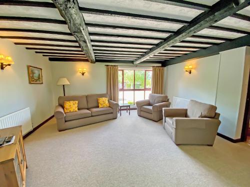a living room with two couches and a table at Fox Cottage - E4510 in Chipping Sodbury