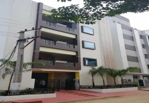 ティルパティにあるHotel O AMR Home Staysの前に木々がある大きな建物