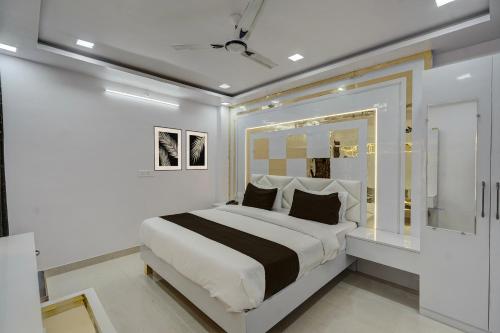 a white bedroom with a large bed with black and white pillows at Hotel O OM SAI HOTEL in Kākori