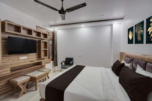 a bedroom with a large bed and a flat screen tv at Hotel O OM SAI HOTEL in Kākori