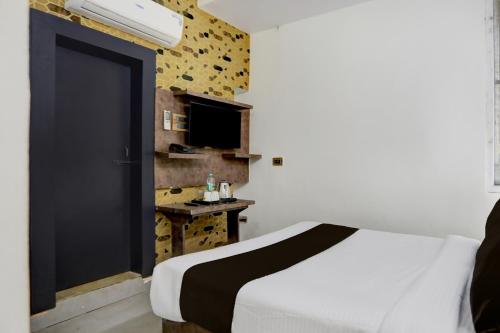 a bedroom with a white bed and a black door at Hotel O Shad Residency in Patna
