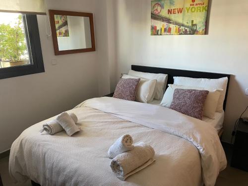 a bedroom with a large bed with towels on it at PLAYA ALMENARA ATICO DUPLEX VISTAS AL MAR Y MONTAÑA WIFI,PISCINA a in Almenara