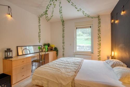 a bedroom with a bed and a dresser and a window at Villa La Chauve Souris in Houffalize