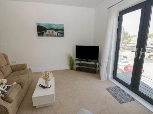 a living room with a couch and a flat screen tv at Sea View Apartment - 2 Bedrooms - Sleeps 4 in Whitehaven