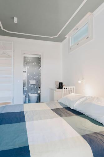 a white bedroom with a bed and a bathroom at A Casa Di Lu Na 3 in Bologna