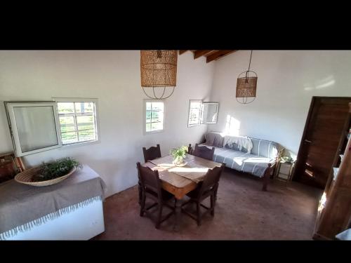een woonkamer met een bed, een tafel en stoelen bij La Chacra in Pilar