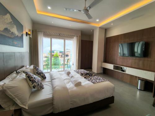 Una cama grande en una habitación con una ventana grande. en Kynjing Suites, en Shillong