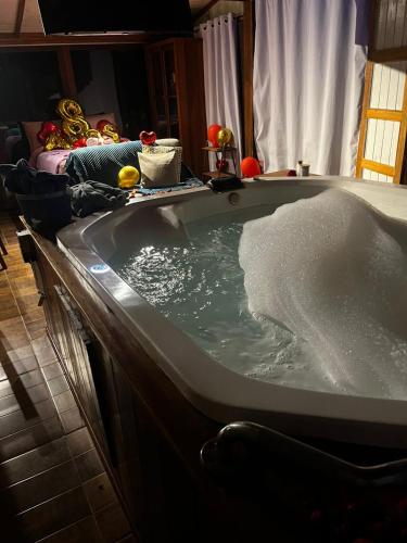 a bath tub filled with water in a bathroom at Cabana Spa São Roque in São Roque