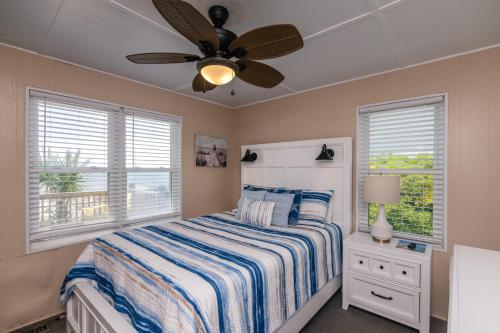 een slaapkamer met een bed en een plafondventilator bij Beach Retreat in Edisto Island