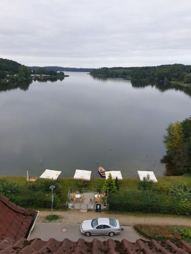 a car parked in front of a large lake at Seeschloss Hotel Kellersee in Eutin