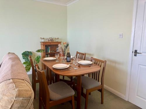 einen Esstisch mit Tellern und Gläsern darauf in der Unterkunft 36 Beach Court - Sea Views, Parking, Balcony in Pembrokeshire