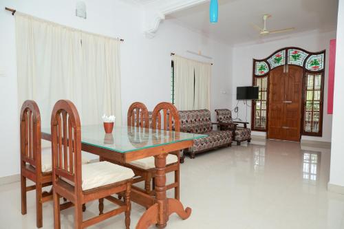 a living room with a table and chairs and a couch at Lakshmi Ayurveda & Yoga Apartment in Kovalam