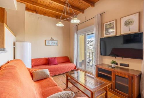 ein Wohnzimmer mit Sofa und Fernseher in der Unterkunft Vista Nevada Ski Lodge in Sierra Nevada