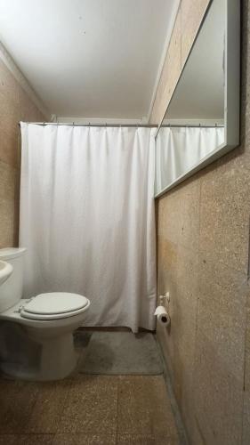 a bathroom with a toilet and a shower curtain at Cayenne | Cozy Apt | Generator/Cistern | Bayamón in Bayamón