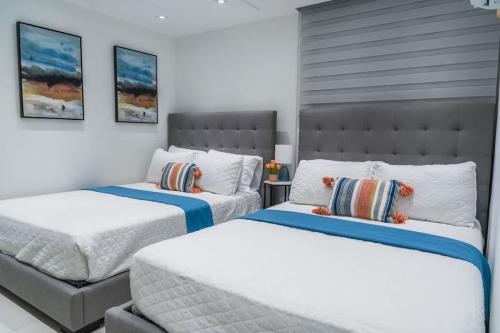 a bedroom with two beds and a headboard at Isla | The Sunset Abode in Ocean Club, Rincón in Corcega
