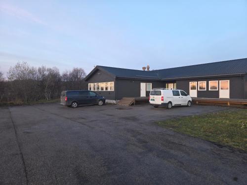 twee auto's geparkeerd op een parkeerplaats voor een huis bij Aurora Andøya in Andøya