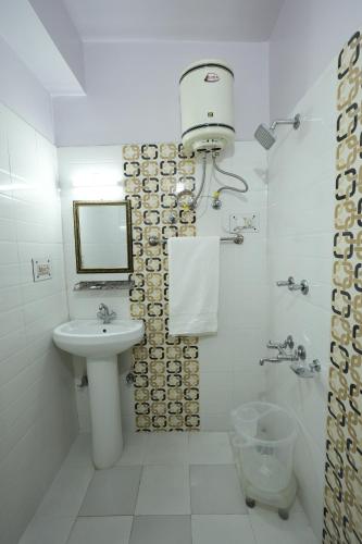 a white bathroom with a sink and a shower at Harmony Sentiments in Shimla