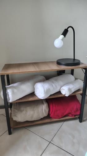 een tafel met kussens en een bureau met een lamp bij Espaço Acalanto in Rio das Ostras