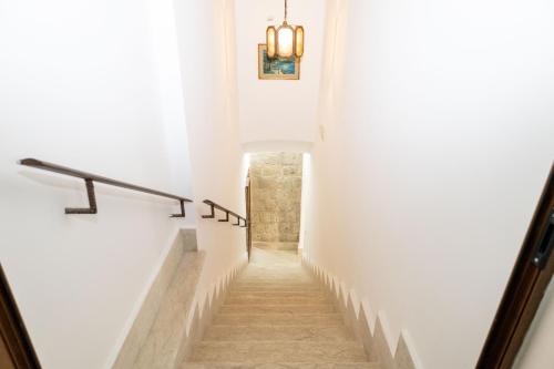 a hallway with white walls and stairs with a light fixture at View, Terrace & Comfort in Sant'Agata de' Goti in SantʼAgata deʼ Goti