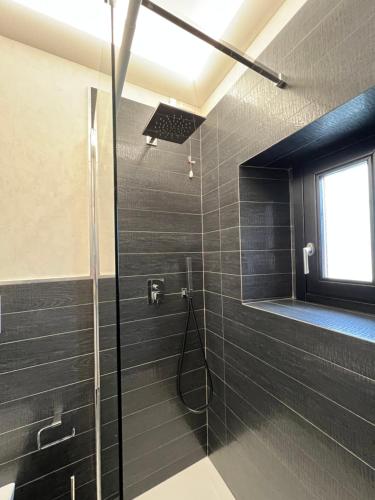 een badkamer met een douche met een glazen deur bij A Casa di Alice in Ginestra