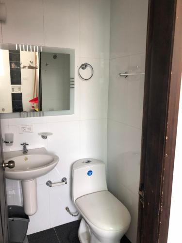 ein weißes Badezimmer mit Toilette und Waschbecken in der Unterkunft Apartamento en el Rodadero in Santa Marta