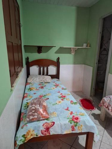 Un dormitorio con una cama con una colcha floral. en Pousada Marudá, en Marapanim