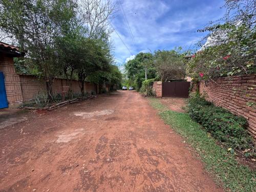 a dirt road with trees and a brick wall at Casa Paraíso do Ribeirão in Lençóis