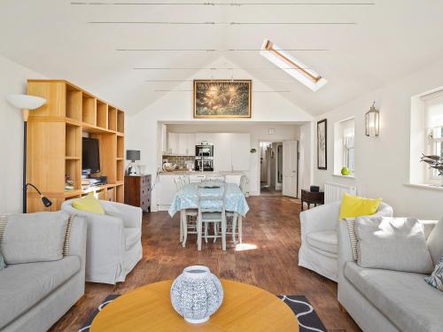 un salon avec des meubles blancs et une table dans l'établissement Carew Cottage, à Manorbier