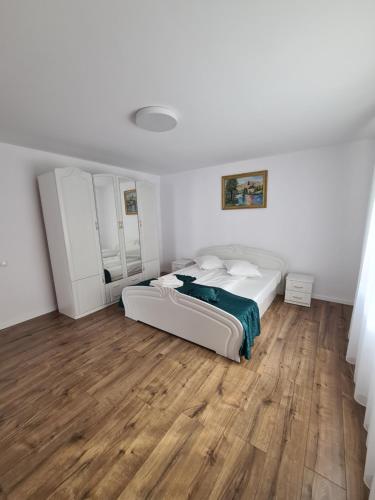 a bedroom with two beds and a wooden floor at Luci's House in Jucu de Mijloc