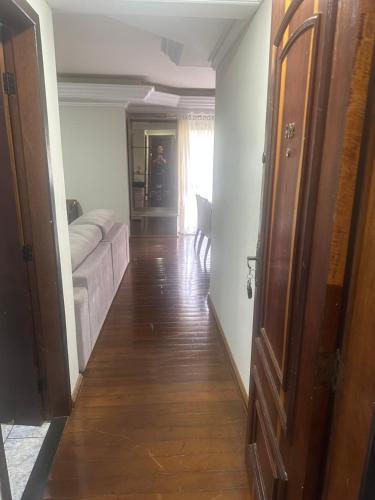 a hallway leading to a living room with a couch at Apartamentos Nadai 302 in Foz do Iguaçu