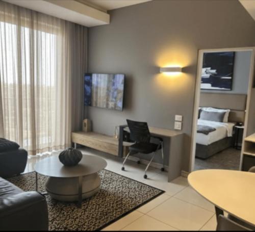 een woonkamer met een bank, een bed en een tafel bij Your Private Space in Soweto