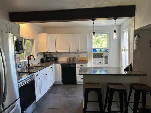 a kitchen with white cabinets and a black refrigerator at New Leeds listing Near Graces diner and Hudson! in Catskill