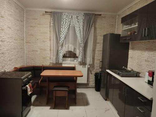 a kitchen with a wooden table in a room at NADENKA & MGR Vendégház in Alsótelekes
