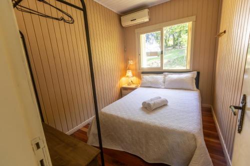 ベント・ゴンサルベスにあるRecanto dos Vinhedosのベッドと窓のある小さな寝室