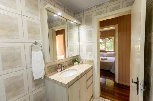 ベント・ゴンサルベスにあるRecanto dos Vinhedosの洗面台と鏡のあるバスルーム