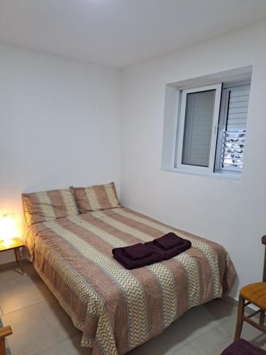 a bed in a white room with a window at The Heart of Moutoullas in Moutoullas