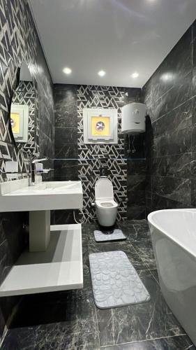 a bathroom with a sink and a toilet and a tub at Three-bedroom apartment in Mohandessin in Cairo