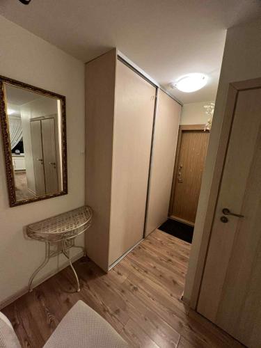 a room with a mirror and a table in it at KT cosy hillside apartment in Mažeikiai