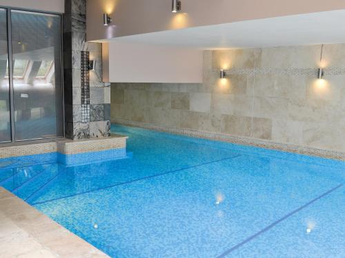 ein großes Schwimmbecken mit blauem Wasser in einem Gebäude in der Unterkunft Moorecroft in Buxton