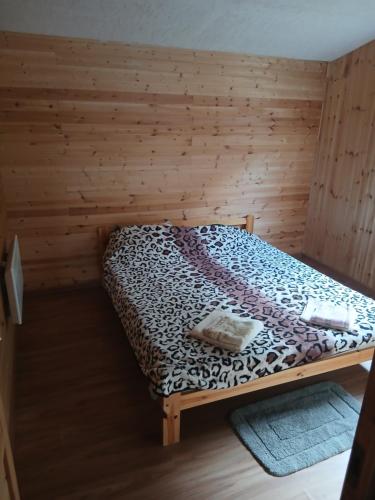 a bedroom with a bed in a wooden room at Sauleskrasti 