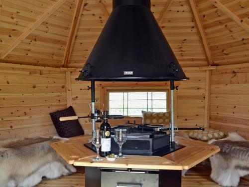 a kitchen with a stove in a log cabin at The Stables- Osb in Penbryn