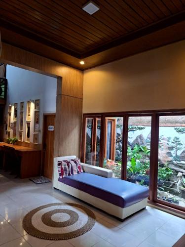 a bedroom with a bed in a room with windows at Mocca Guest House in Banyuwangi