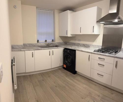 a kitchen with white cabinets and a black dishwasher at Home 4 Home short stay in Warren