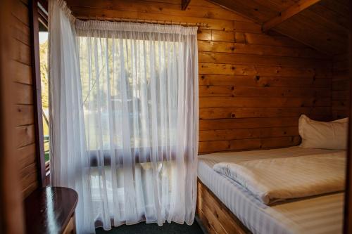 a bedroom with a window in a log cabin at Casuta Verde Bicaz in Bicaz
